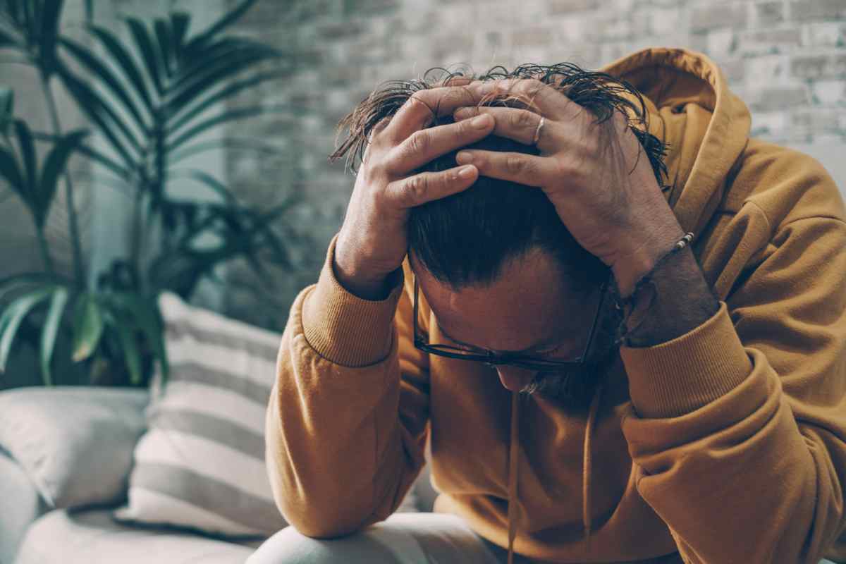 un ragazzo che si dispera con le mani sui capelli